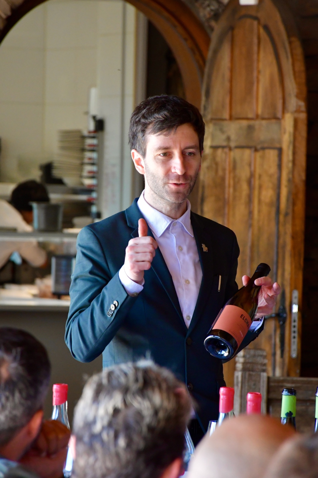 Patricio Zárate presentando una botella ante los comensales